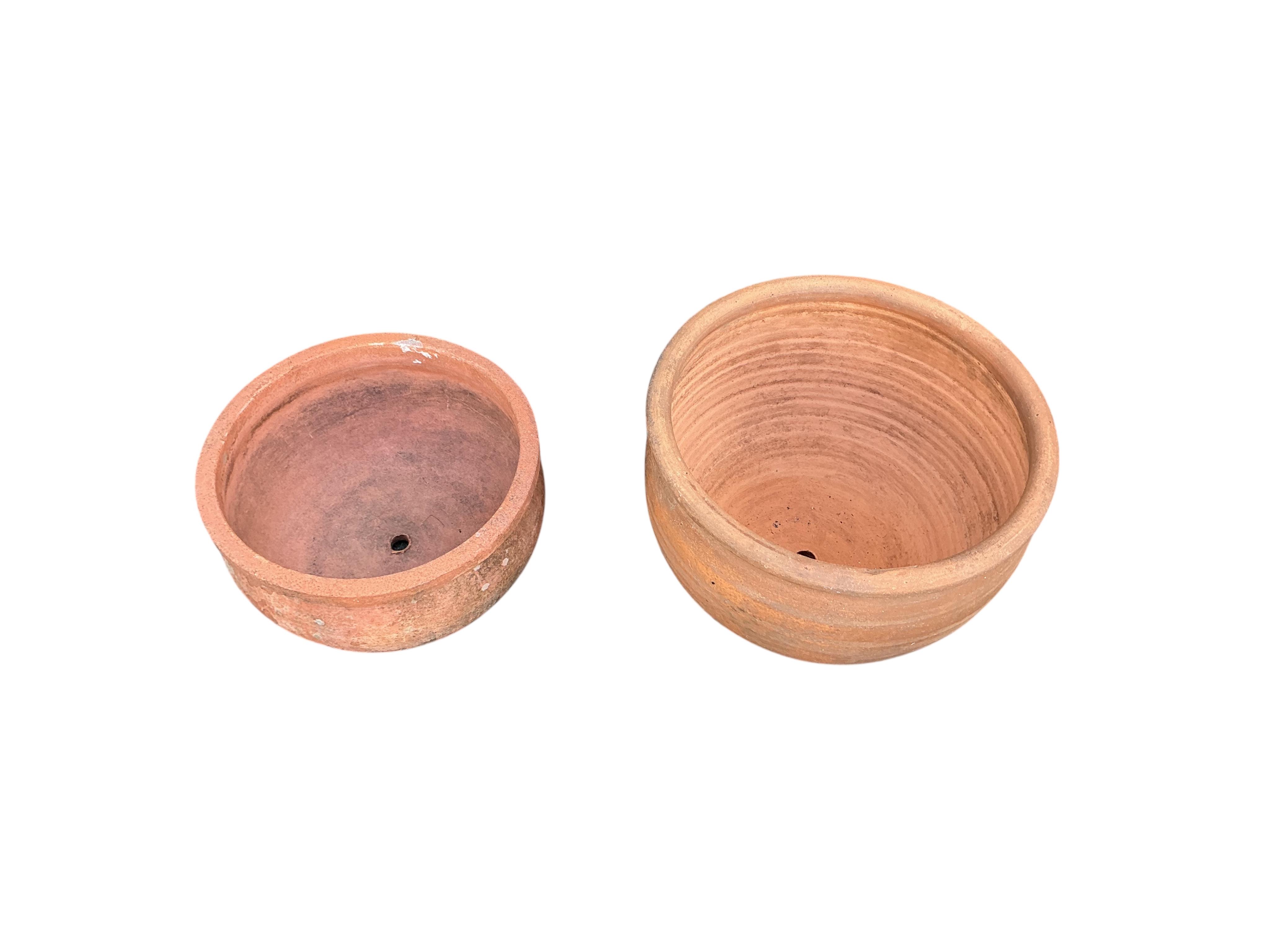 Three terracotta pots and a blue glazed pot, largest diameter 50cm, height 21cm